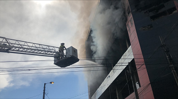 Bomberos en camión escalera apagando un incendio en una empresa