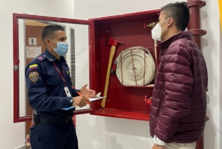 Dos personas de frente al lado de un punto de emergencia 