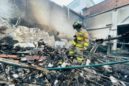 Bombero sobre las cenizas de una empresa