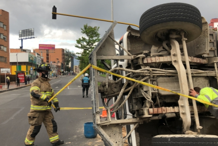Bombero al lado de un carro volteado